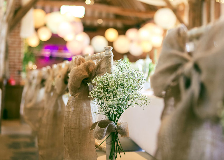 Chairs decorated with flowers for a wedding at Haughley Park Barn Wedding venue photographed by Suffolk Wedding Photographers Hayley Denston Photography