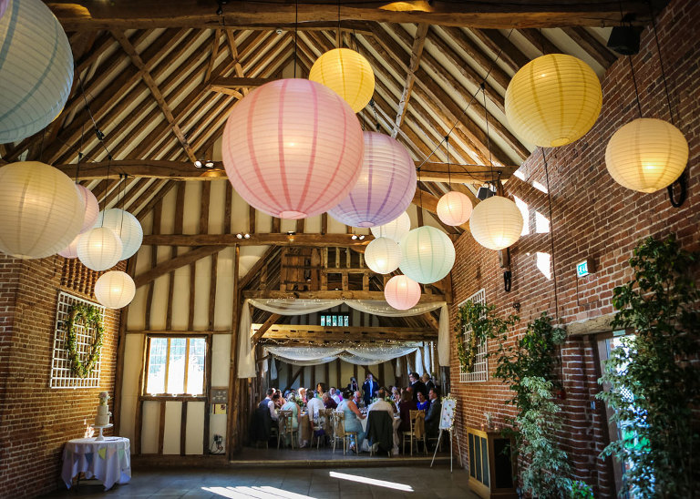 A wedding reception with paper globe lighting at Haughley Park Barn Wedding Venue photographed by Suffolk Wedding Photographers Hayley Denston Photography
