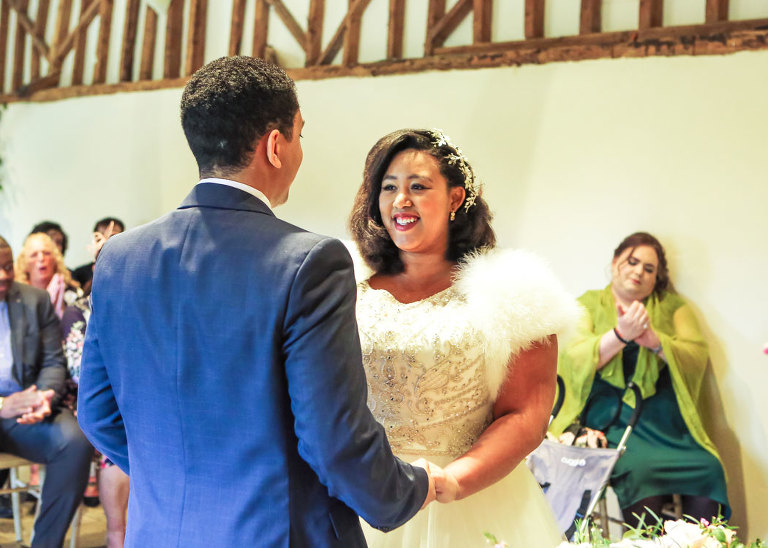 A bride looking at her groom during their wedding ceremony at Haughley Park Barn Wedding Venue photographed by Suffolk Wedding Photographers Hayley Denston Photography