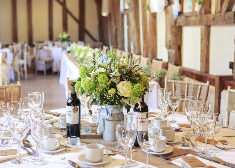 A green and white floral centre piece set up for a wedding breakfast at Haughley Park Barn Wedding Venue photographed by Suffolk Wedding Photographers Hayley Denston Photography