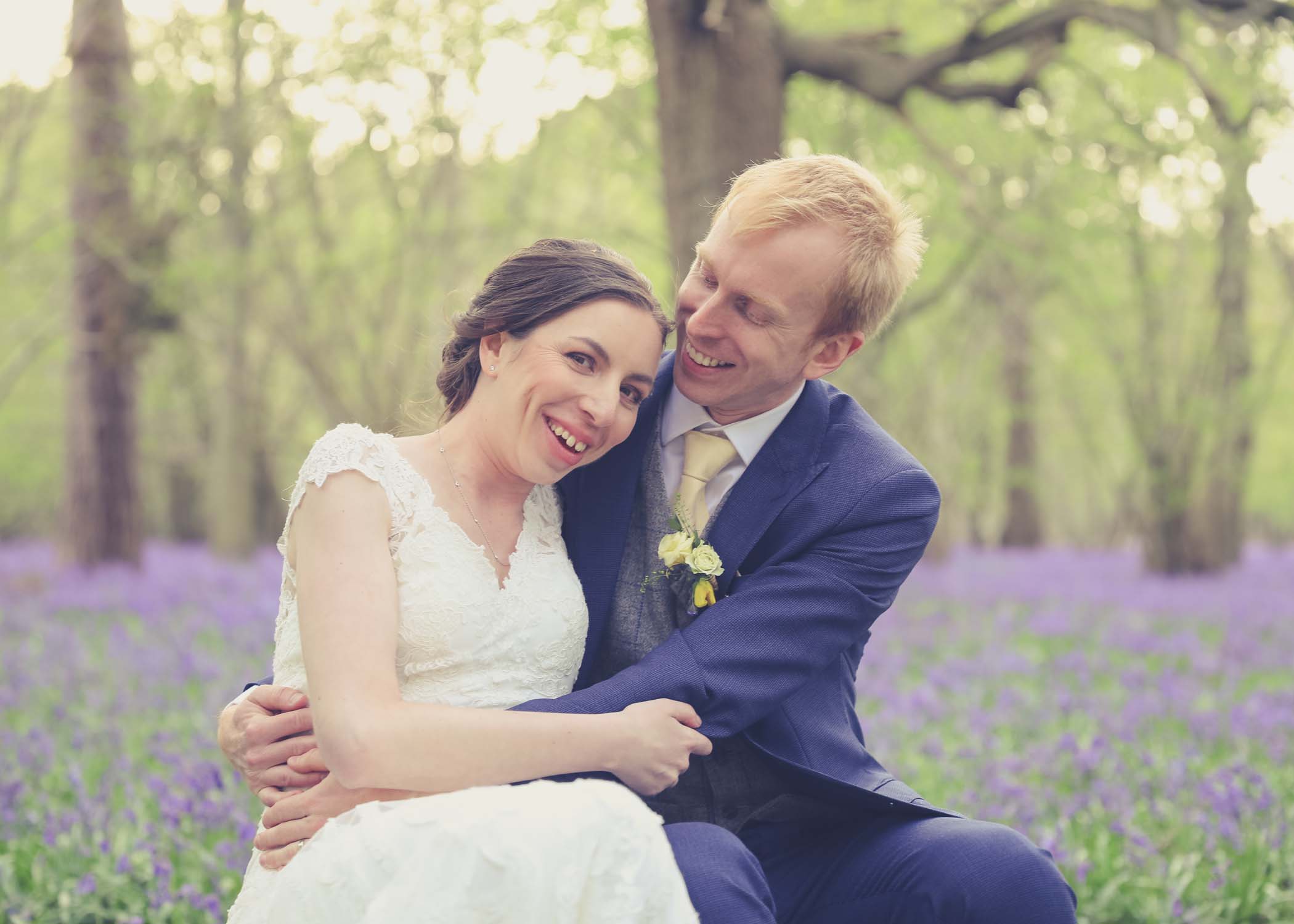 A bride and a groom together in a bluebell wood on their wedding day at Haughley Park Barn Wedding Venue photographed by Hayley Denston Photography