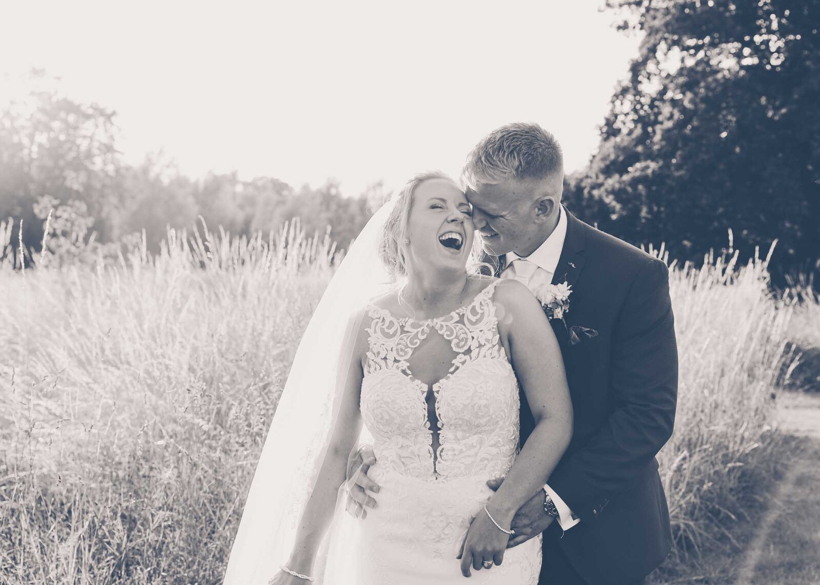 A bride and groom in the meadow at Easton Grange Wedding Venue on their wedding day photographed by Suffolk Wedding Photographers Hayley Denston Photography