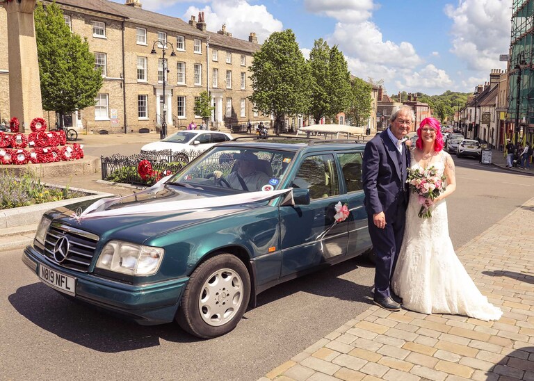 A bride and her dad laughing by a vintage mercedes car on a wedding day at Bury St Edmunds Registry Office in Suffolk captured by Suffolk Wedding Photographers Hayley Denston Photography