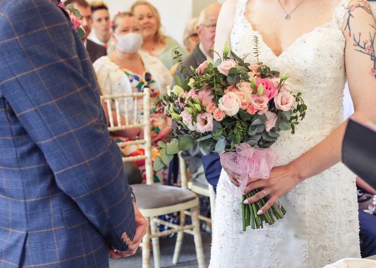 A bride and groom during their wedding ceremony at Bury St Edmunds Registry Office on their wedding day in Suffolk captured by Suffolk Wedding Photographers Hayley Denston Photography