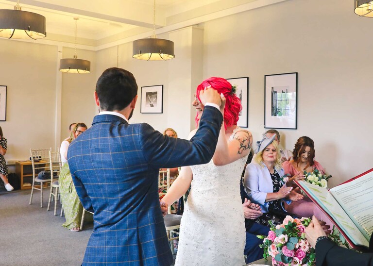 A bride and groom during their wedding ceremony at Bury St Edmunds Registry Office on their wedding day in Suffolk captured by Suffolk Wedding Photographers Hayley Denston Photography