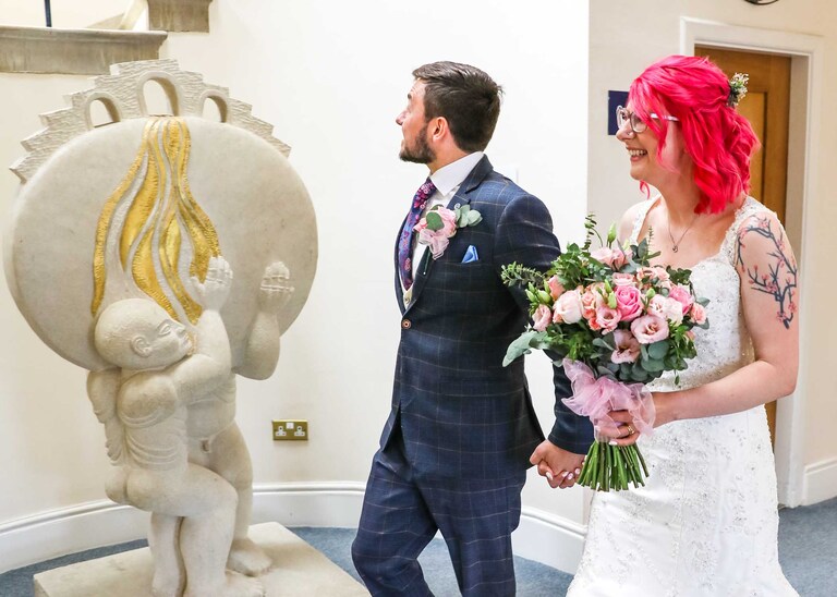 A bride and groom walking out of their ceremony at Bury St Edmunds Registry Office on their wedding day in Suffolk captured by Suffolk Wedding Photographers Hayley Denston Photography