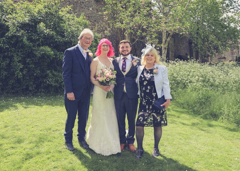 A family portrait of a bride and groom and their family in the Abbey Gardens in Bury St Edmunds on a wedding day in Suffolk captured by Suffolk Wedding Photographers Hayley Denston Photography
