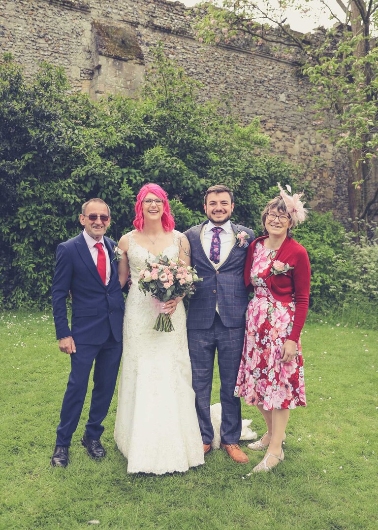 A family portrait of a bride and groom and their family in the Abbey Gardens in Bury St Edmunds on a wedding day in Suffolk captured by Suffolk Wedding Photographers Hayley Denston Photography
