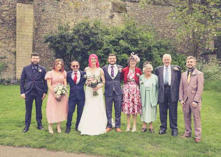 A family portrait of a bride and groom and their family in the Abbey Gardens in Bury St Edmunds on a wedding day in Suffolk captured by Suffolk Wedding Photographers Hayley Denston Photography