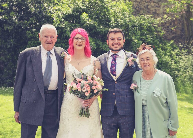 A family portrait of a bride and groom and their family in the Abbey Gardens in Bury St Edmunds on a wedding day in Suffolk captured by Suffolk Wedding Photographers Hayley Denston Photography