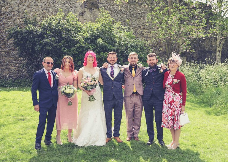 A family portrait of a bride and groom and their family in the Abbey Gardens in Bury St Edmunds on a wedding day in Suffolk captured by Suffolk Wedding Photographers Hayley Denston Photography