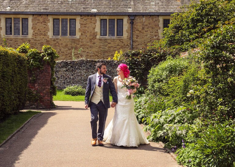 A bride and groom walking in the Abbey Gardens in Bury St Edmunds on a wedding day in Suffolk captured by Suffolk Wedding Photographers Hayley Denston Photography