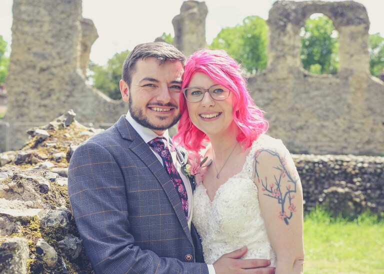 A bride and groom with the Abbey ruins behind them in the Abbey Gardens in Bury St Edmunds on a wedding day in Suffolk captured by Suffolk Wedding Photographers Hayley Denston Photography