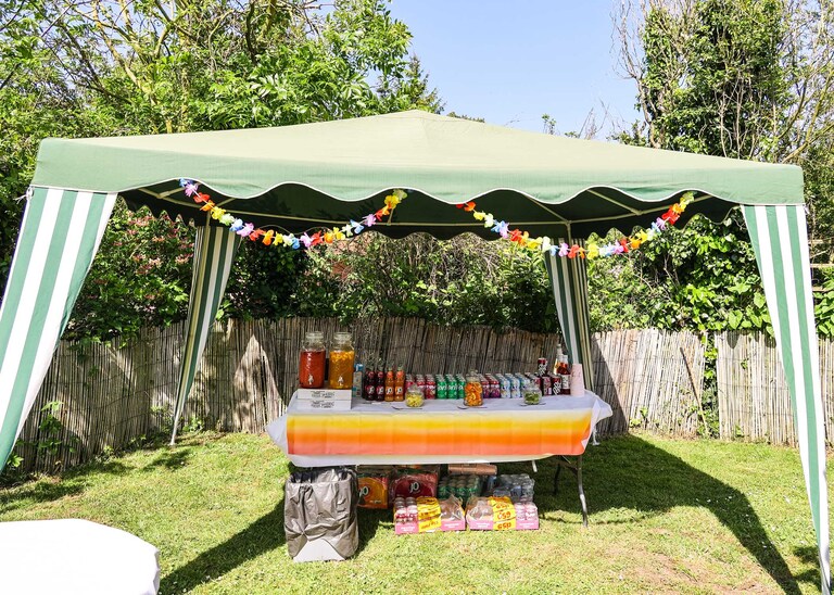 A drinks tent in a back garden wedding reception on a wedding day in Suffolk captured by Suffolk Wedding Photographers Hayley Denston Photography