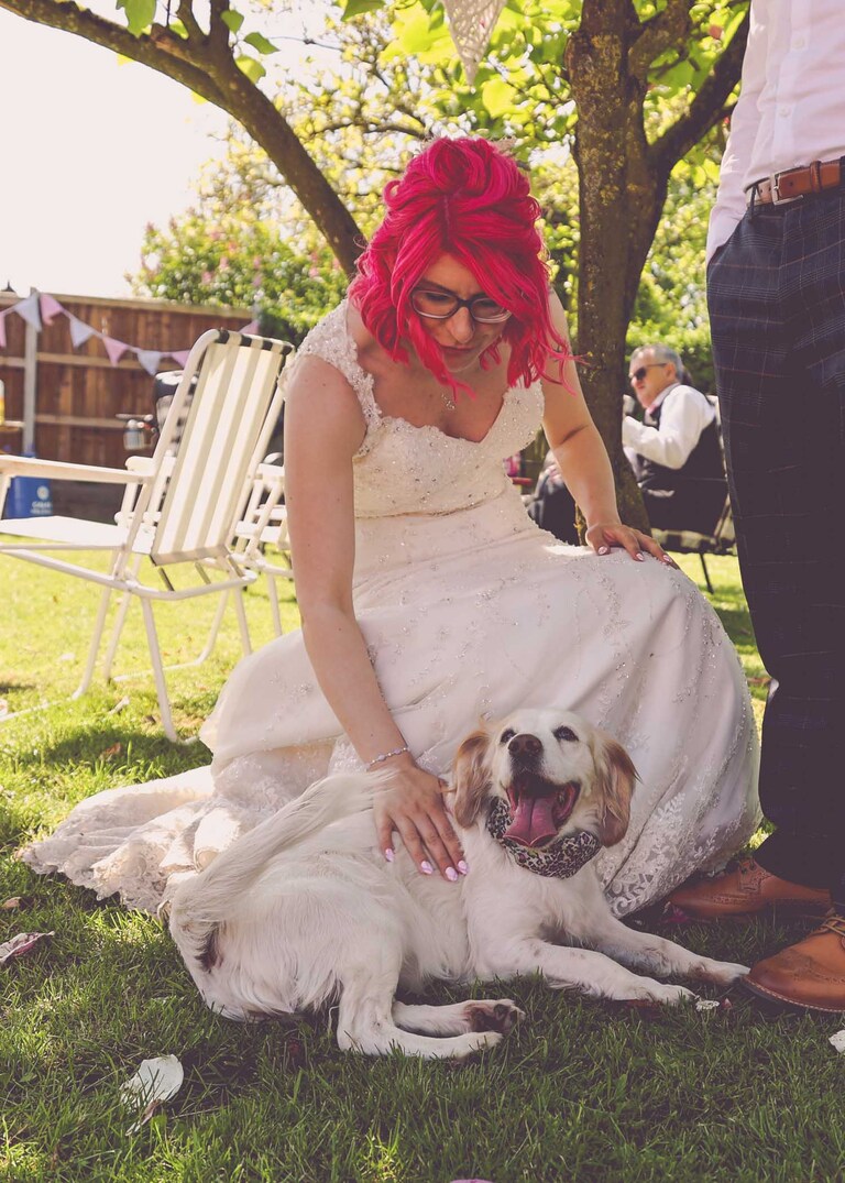 A bride smoothing her dog on a wedding day in Suffolk captured by Suffolk Wedding Photographers Hayley Denston Photography
