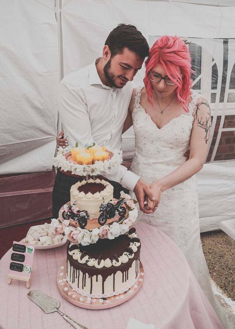 A bride and groom cutting their wedding cake on a wedding day in Suffolk captured by Suffolk Wedding Photographers Hayley Denston Photography