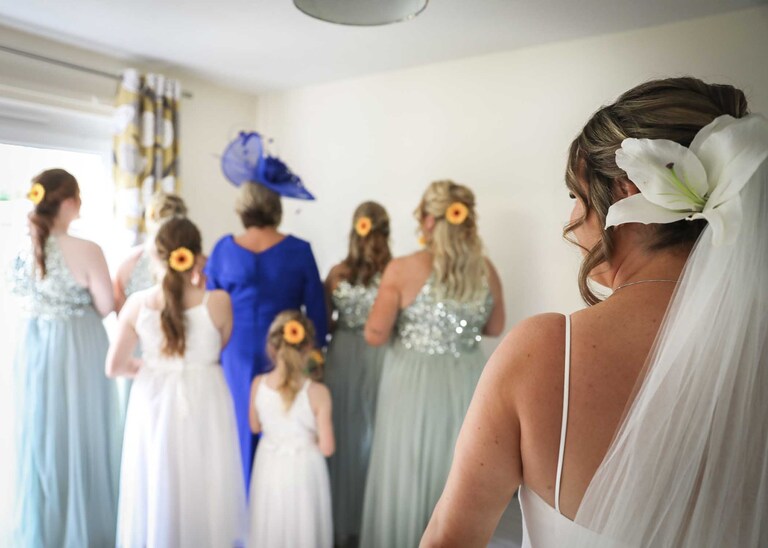 A bride waiting for bridesmaids. flowergirls and mums to turn round and see her dress reveal on her wedding day at Hungarian Hall on a Wedding Day photographed by Suffolk Wedding Photographers Hayley Denston Photography