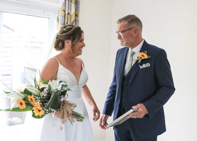 A bride and her dad after she has given him a wedding gift at Hungarian Hall on a Wedding Day photographed by Suffolk Wedding Photographers Hayley Denston Photography