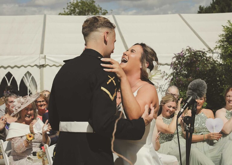 A bride laughing with her groom after they are just married at Hungarian Hall on a Wedding Day photographed by Suffolk Wedding Photographers Hayley Denston Photography