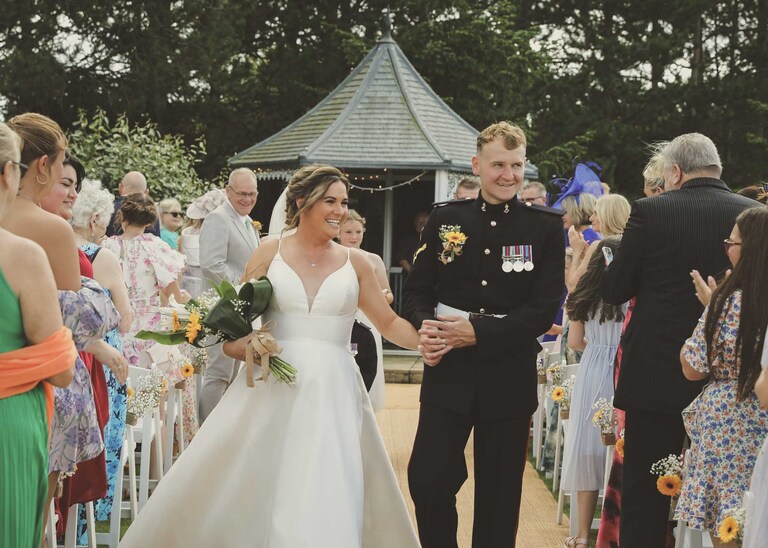A bride and groom walking down the aisle after getting married at Hungarian Hall on a Wedding Day photographed by Suffolk Wedding Photographers Hayley Denston Photography