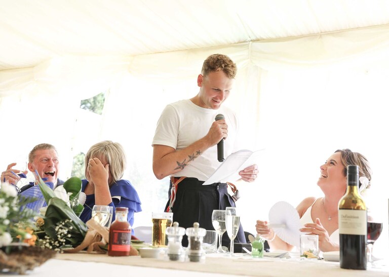 A groom giving his speech to his bride at Hungarian Hall on a Wedding Day photographed by Suffolk Wedding Photographers Hayley Denston Photography