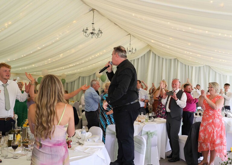 A singing waiter giving his performance at Hungarian Hall on a Wedding Day photographed by Suffolk Wedding Photographers Hayley Denston Photography