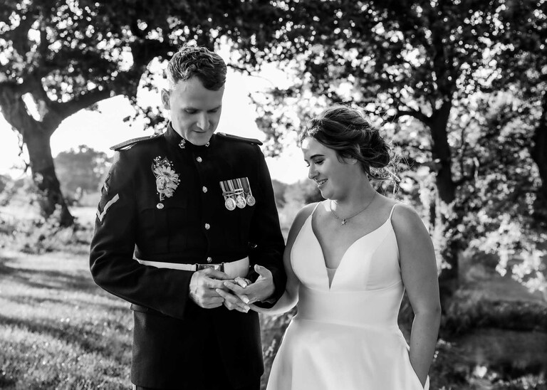 A groom looking at his brides wedding ring on her hand at Hungarian Hall on a Wedding Day photographed by Suffolk Wedding Photographers Hayley Denston Photography