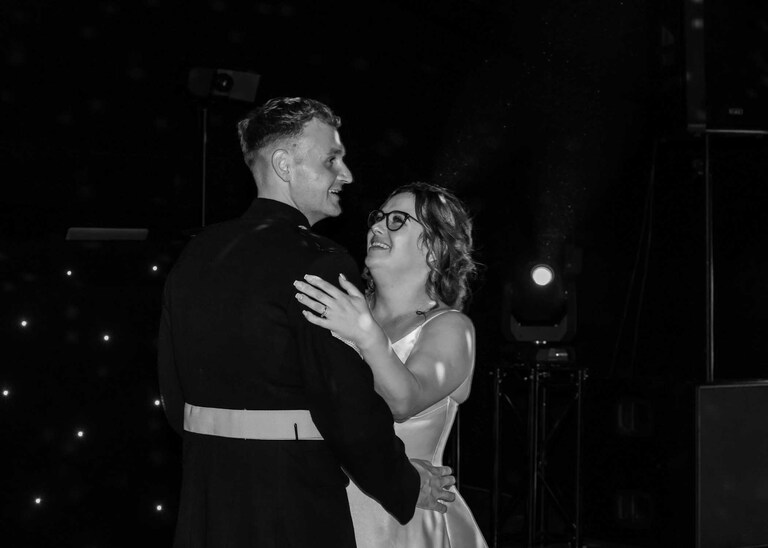 A bride and groom smiling during their first dance at Hungarian Hall on a Wedding Day photographed by Suffolk Wedding Photographers Hayley Denston Photography