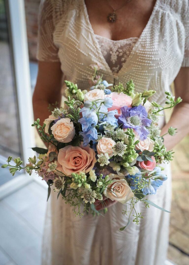 A beautiful pastel brides bouquet with scabious, roses, astrantia, dephiniums and antirhinums by Suffolk Wedding Photographers Hayley Denston Photography