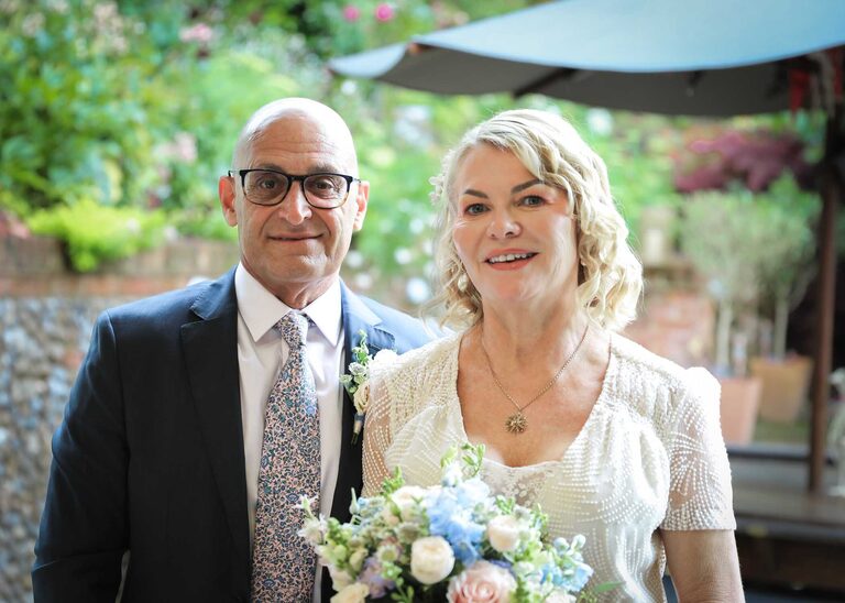 A bride and groom on their rainy wedding day at Letheringham Water Mill by Suffolk Wedding Photographers Hayley Denston Photography