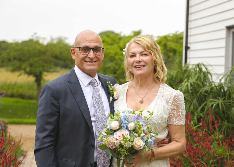 A bride and groom in the rain at Letheringham Water Mill on their wedding day by Suffolk Wedding Photographers Hayley Denston Photography