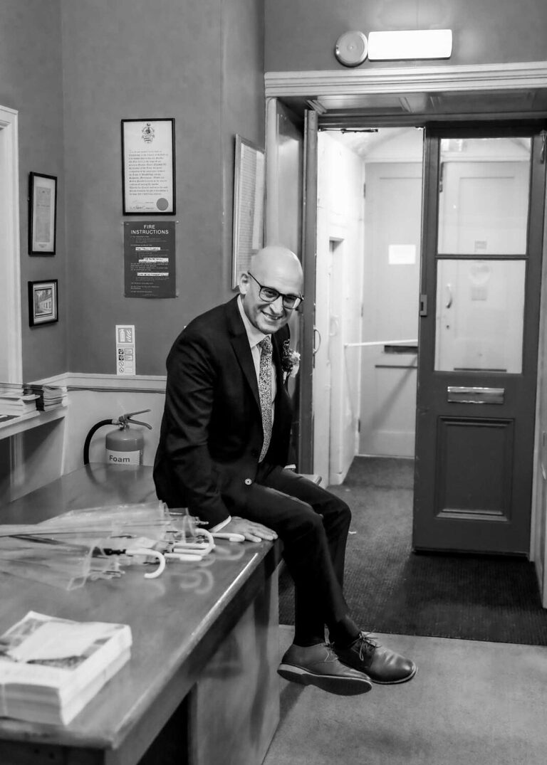 A groom waiting for his wedding ceremony at Woodbridge Shire Hall on a rainy day photographed by Suffolk Wedding Photographers Hayley Denston Photography