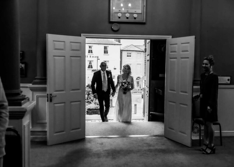 A bride and groom entering their wedding ceremony at Woodbridge Shire Hall photographed by Suffolk Wedding Photographers Hayley Denston Photography