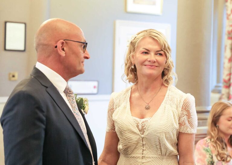 A bride and groom holding hands at a wedding ceremony at Woodbridge Shire Hall photographed by Suffolk Wedding Photographers Hayley Denston Photography