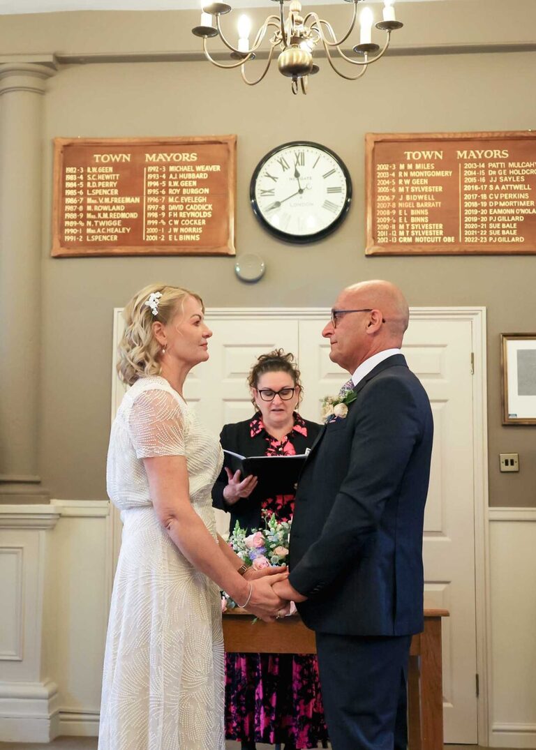 A bride and groom holding hands at a wedding ceremony at Woodbridge Shire Hall photographed by Suffolk Wedding Photographers Hayley Denston Photography