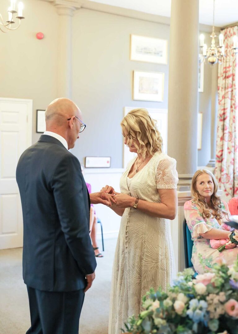 A bride and groom exchanging rings at a wedding ceremony at Woodbridge Shire Hall photographed by Suffolk Wedding Photographers Hayley Denston Photography