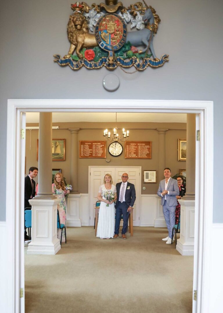 A bride and groom ready to exit the ceremony room on a rainy wedding day at Woodbridge Shire Hall photographed by Suffolk Wedding Photographers Hayley Denston Photography