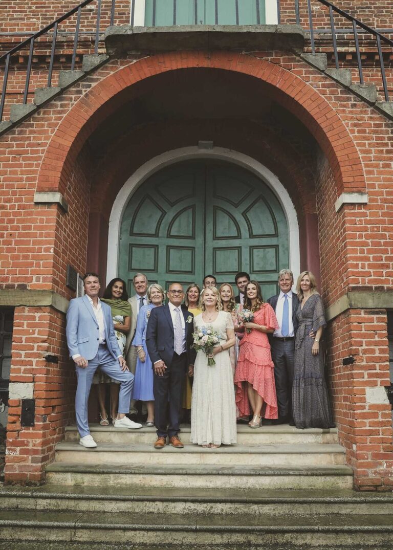 A group photo on a rainy wedding day at Woodbridge Shire Hall photographed by Suffolk Wedding Photographers Hayley Denston Photography