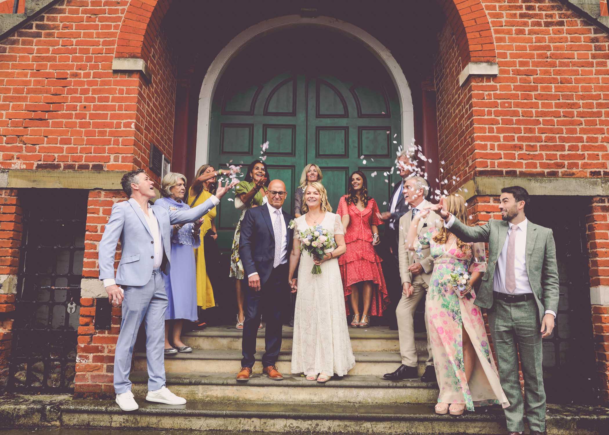 A small and intimate confetti photo on a rainy wedding day at Woodbridge Shire Hall photographed by Suffolk Wedding Photographers Hayley Denston Photography