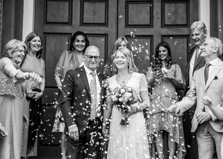 A black and white confetti photo on a rainy wedding day at Woodbridge Shire Hall photographed by Suffolk Wedding Photographers Hayley Denston Photography