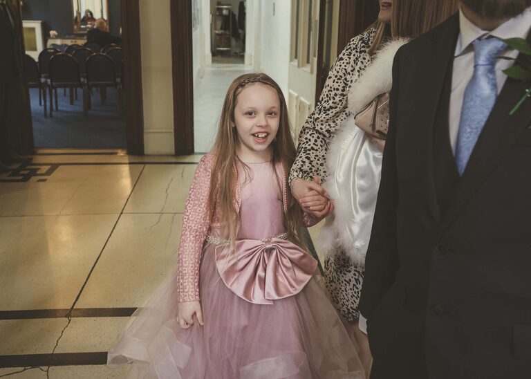 A flowergirl at a wedding in a pink dress at Ipswich Town Hall taken by Suffolk Wedding Photographer Hayley Denston Photography