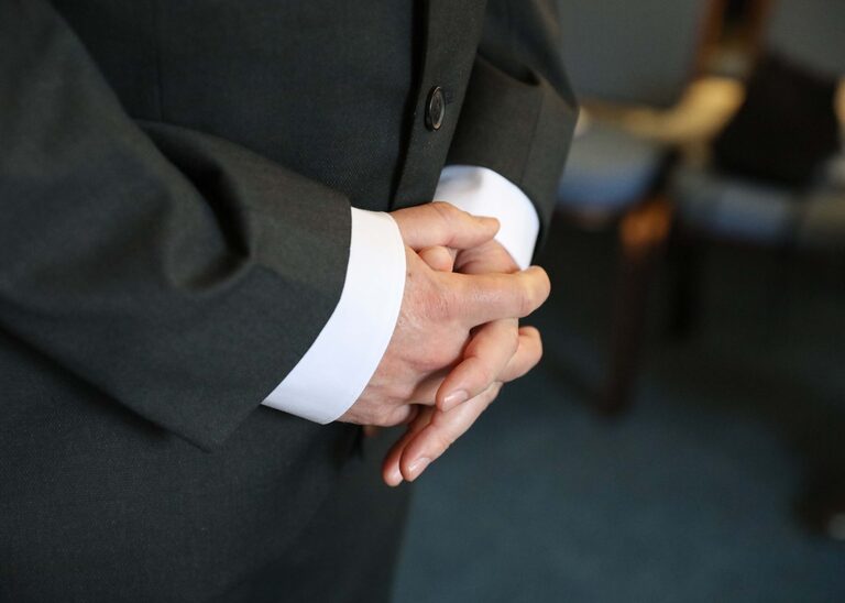 A grooms hands held together waiting for his bride to arrive for their ceremony at Ipswich Town Hall taken by Suffolk Wedding Photographer Hayley Denston Photography