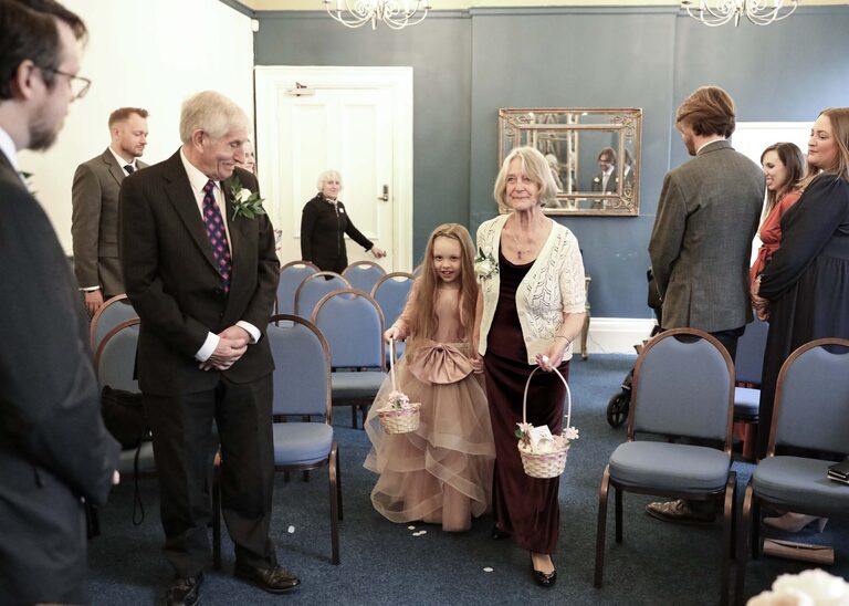 An older and younger flowergirl coming in for a ceremony at Ipswich Town Hall taken by Suffolk Wedding Photographer Hayley Denston Photography