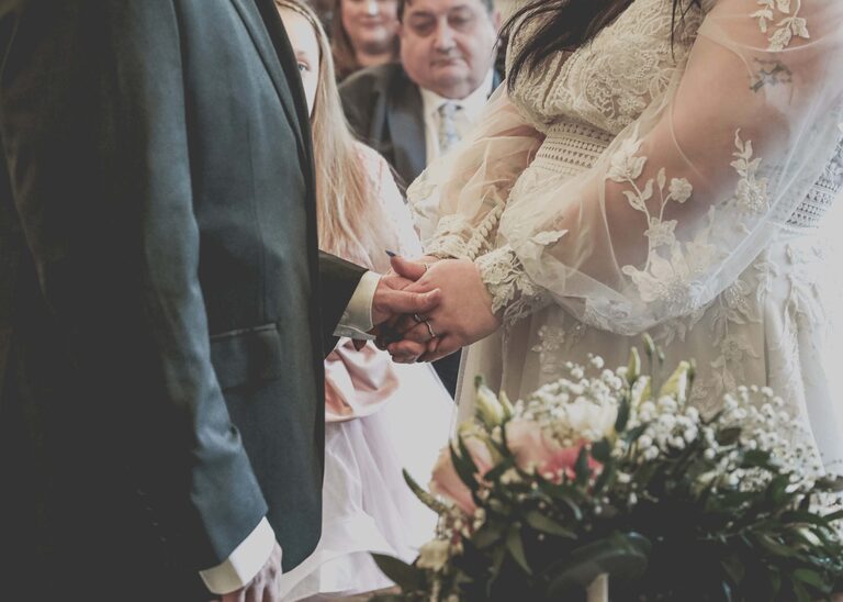 A bride and groom holding hands during their wedding ceremony at Ipswich Town Hall taken by Suffolk Wedding Photographer Hayley Denston Photography