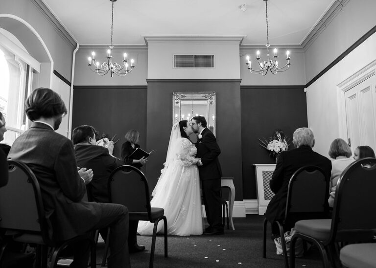 A bride and groom kissing at their wedding ceremony at Ipswich Town Hall taken by Suffolk Wedding Photographer Hayley Denston Photography