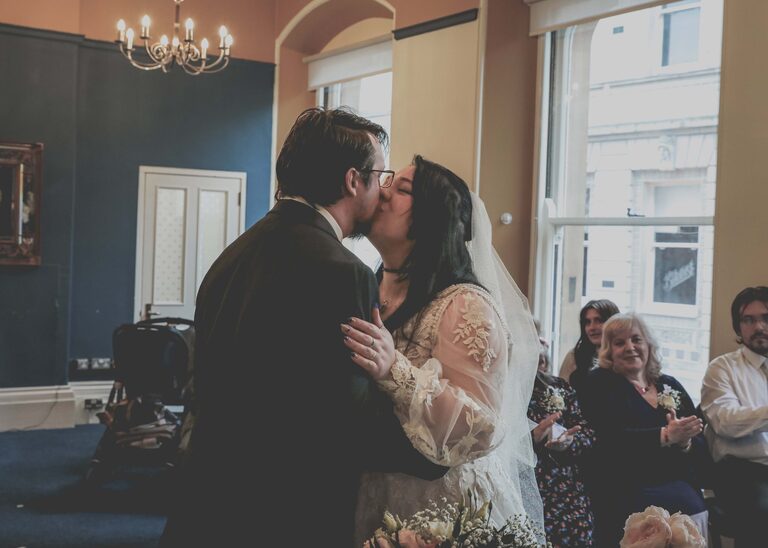 A bride and groom kissing during their wedding ceremony at Ipswich Town Hall taken by Suffolk Wedding Photographer Hayley Denston Photography
