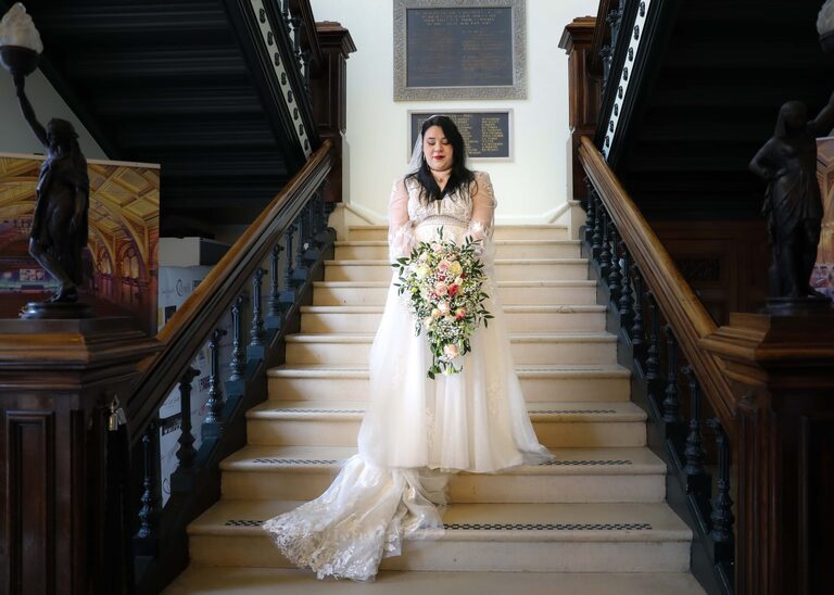 A bride on the stairs at Ipswich Town Hall taken by Suffolk Wedding Photographer Hayley Denston Photography