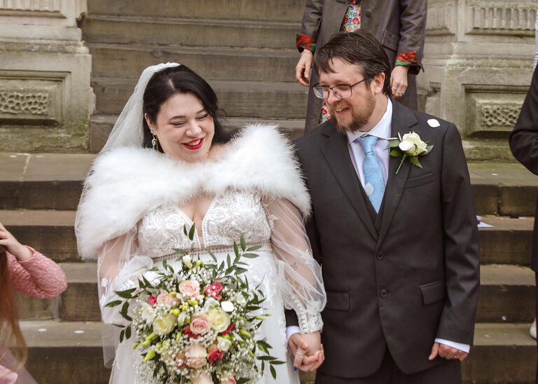 A bride and groom laughing with each other on their wedding day at Ipswich Town Hall taken by Suffolk Wedding Photographer Hayley Denston Photography
