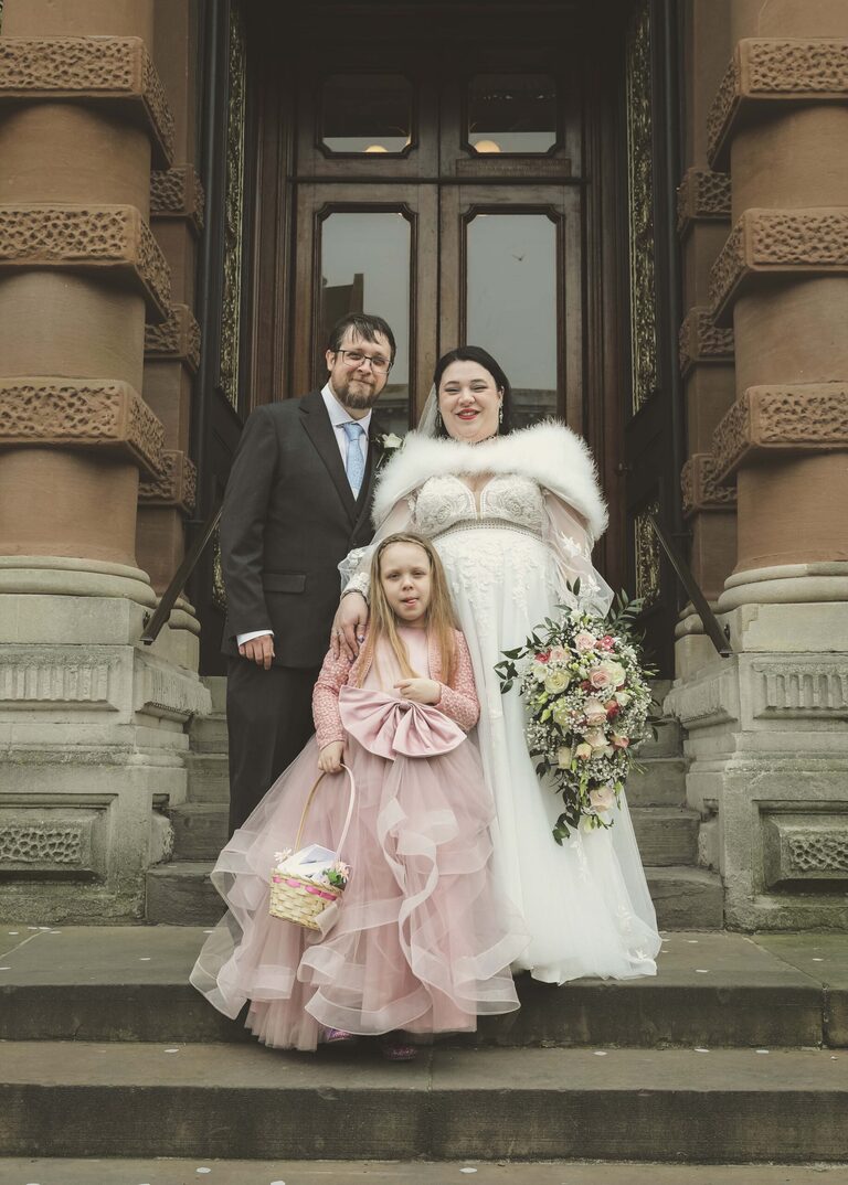 A bride and groom and their daughter on the steps at Ipswich Town Hall taken by Suffolk Wedding Photographer Hayley Denston Photography