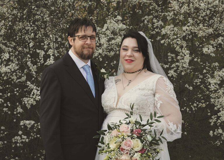 A bride and groom on their wedding day in suffolk in front of a white flowering cherry taken by Suffolk Wedding Photographer Hayley Denston Photography